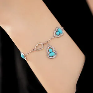 Detailed view of 18K gold-plated zircon gourd bracelet with blue stones on wrist
