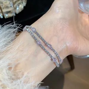Close-up of zircon bracelet on wrist with pink accents and elegant white fuzzy sleeve