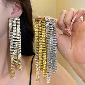 Close-up detail of long cascading metal mesh tassel earrings in gold and silver finish