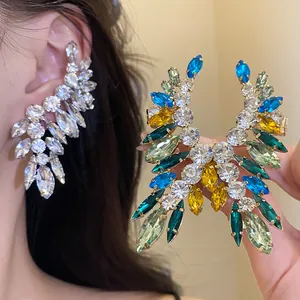 Detail view of colorful wing-shaped rhinestone earrings with crystal embellishments