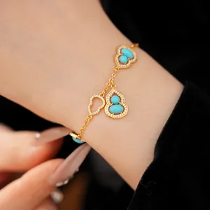 Detailed close-up of a gold-plated bracelet with turquoise gourd charms and paved zircons