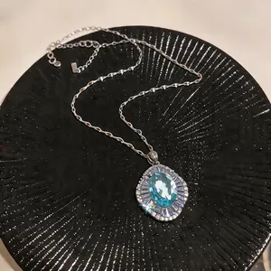 Detailed macro shot of a vintage light blue zircon necklace on a textured black plate.