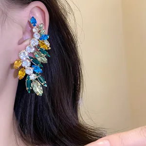 Detailed macro shot of a vibrant colorful rhinestone ear cuff with blue and green gems