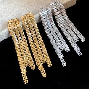 Close-up of elegant gold and silver asymmetric tassel earrings with metallic mesh texture