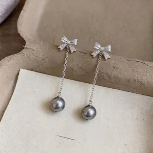 Elegant bow stud earrings with long chain tassel and grey pearl drops.