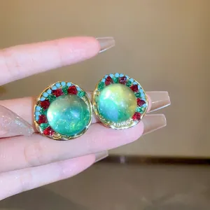 Detailed close-up of round forest style earrings with green stones and colorful beads