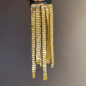 Detailed close-up of gold mesh fringe earrings featuring a vintage asymmetric design.