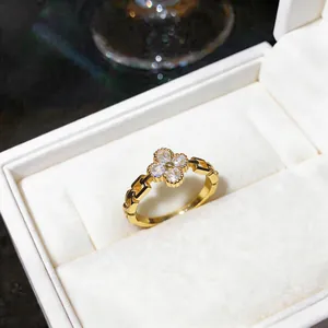 Primo piano di un elegante anello dorato con fiore di zircone in una scatola bianca