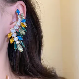 Macro view of a vibrant multi-color marquise crystal ear cuff accessory on ear
