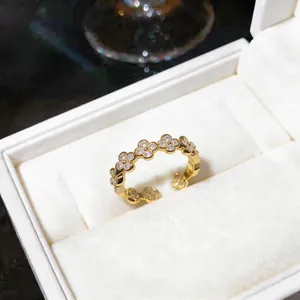 Primo piano di un anello a trifoglio dorato con zirconi incastonati in scatola regalo