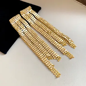 Detailed view of luxury gold mesh tassel earrings displayed on black velvet pouch