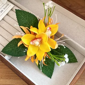 Detailed macro view of a handmade yellow fabric orchid flower hair clip with leaves