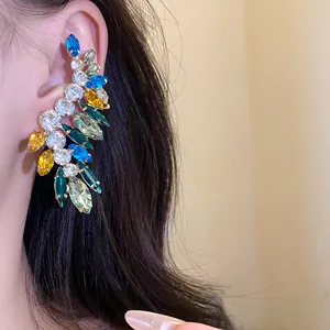 Close-up detail of a colorful rhinestone leaf-shaped ear cuff earring for a high-end fashion look