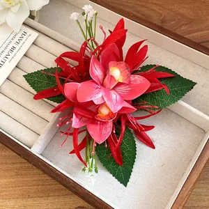 Detailed view of an elegant red fabric orchid hair clip with green leaves in a box.