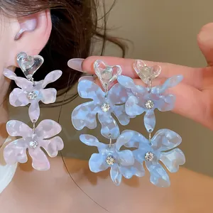 Detailed macro view of elegant acetate flower drop earrings with sparkling rhinestones