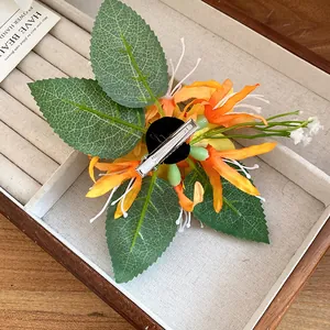 Back view detail of a handmade orange fabric flower hair clip with silver duckbill clip