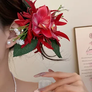 Detailed view of a stylish red fabric flower hair clip accessory worn by a model