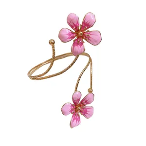 Elegant pink enamel flower arm ring with gold-tone adjustable wrap design for women