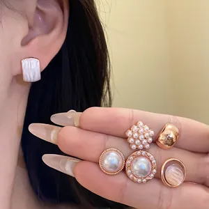 Primer plano detallado de elegantes pendientes geométricos de perlas de resina en rosa
