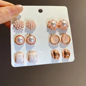 Primer plano de un set de 6 pares de pendientes de oro rosa con perlas de resina