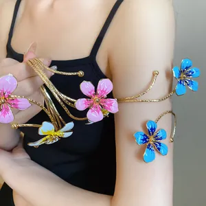 Detailed view of a vintage gold metal arm cuff decorated with colorful oil-dripped flowers