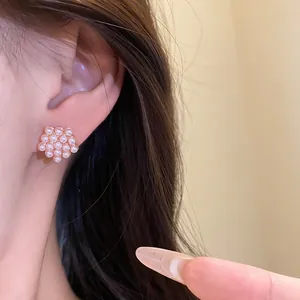 Vista de cerca detallada de pendientes geométricos de perlas de resina en la oreja