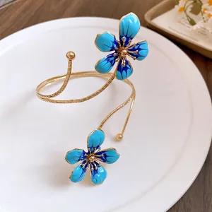 Macro detail of the elegant blue enamel flower petals on the gold-tone metal armlet