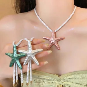Vue détaillée de pendentifs d'étoile de mer en émail coloré avec cordes blanches sur mannequin
