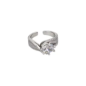 Elegant silver-colored open ring featuring zircon and a twisted pavé-set band design
