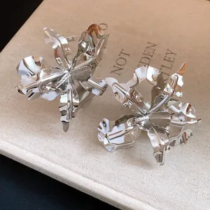Detailed close-up shot showing the metallic texture of large silver flower-shaped rings