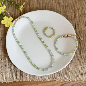 Detailed view of a fresh green glass bead jewelry set with necklace, bracelet and ring.