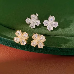 Detailed view of elegant gold and silver flower clip-on earrings with sparkling zircons