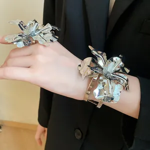 Detailed view of the metallic flower jewelry set including ring and bangle in silver.