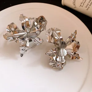 Detailed close-up of silver-toned metal flower rings with hammered petal textures.