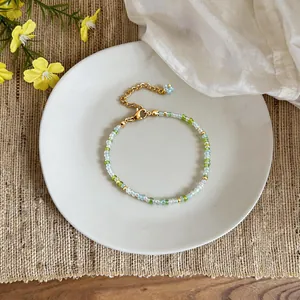 Detail of handmade green and white glass beaded bracelet with gold-tone clasp