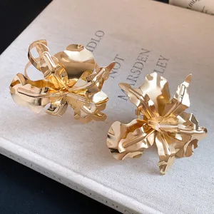 Detail view of elegant large golden metal flower open rings and bracelet jewelry set