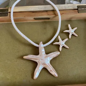 Vue détaillée du collier pendentif étoile de mer nacrée et des boucles d'oreilles