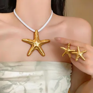 Gros plan d'un collier pendentif étoile de mer dorée et d'une parure de bijoux sur mannequin