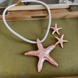 Détail du collier pendentif étoile de mer rose nacré avec ensemble de boucles d'oreilles