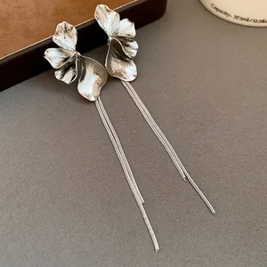 Close-up detail showing the metallic texture of silver flower tassel drop earrings