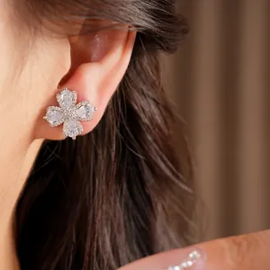 Detailed view of flower-shaped cubic zirconia ear clips worn by a model