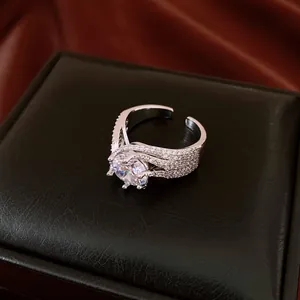 Detail view of an elegant silver twisted open ring with a sparkling round zircon