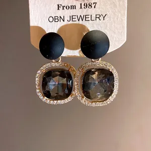 Elegant black matte studs with grey faceted crystal dangles and rhinestone accents