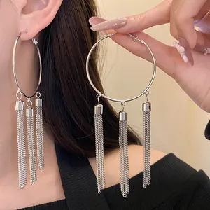 Detail view of large silver hoop earrings with elegant chain tassel fringe