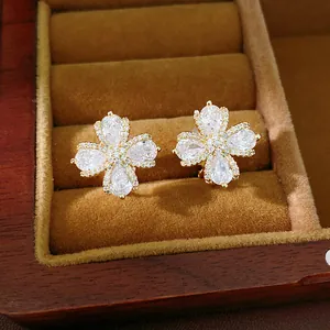 Detailed macro view of elegant gold-plated zircon flower clip-on earrings in jewelry box