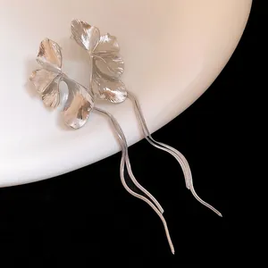 Close-up detail of elegant silver flower tassel earrings with intricate textured metallic petals