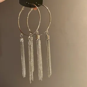 Detailed shot of silver hoop earrings with long chain tassels in a vintage style.