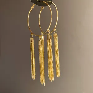 Macro view of gold hoop earrings featuring multi-strand dangling chain tassels.