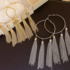 Close-up detail of vintage style gold and silver hoop earrings with elegant long chain tassels