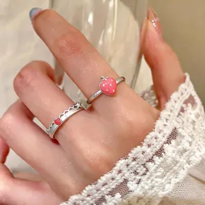 Anello regolabile fragola in smalto rosa con un delicato bordo in pizzo sul dito